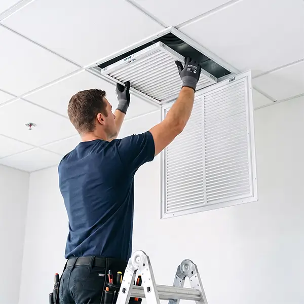 Technician reviewing clean air vent grilles for improved room airflow and HVAC performance in Tomball Texas